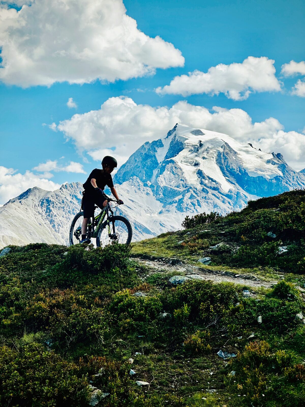 Mountain biking with a snow-capped peak behind